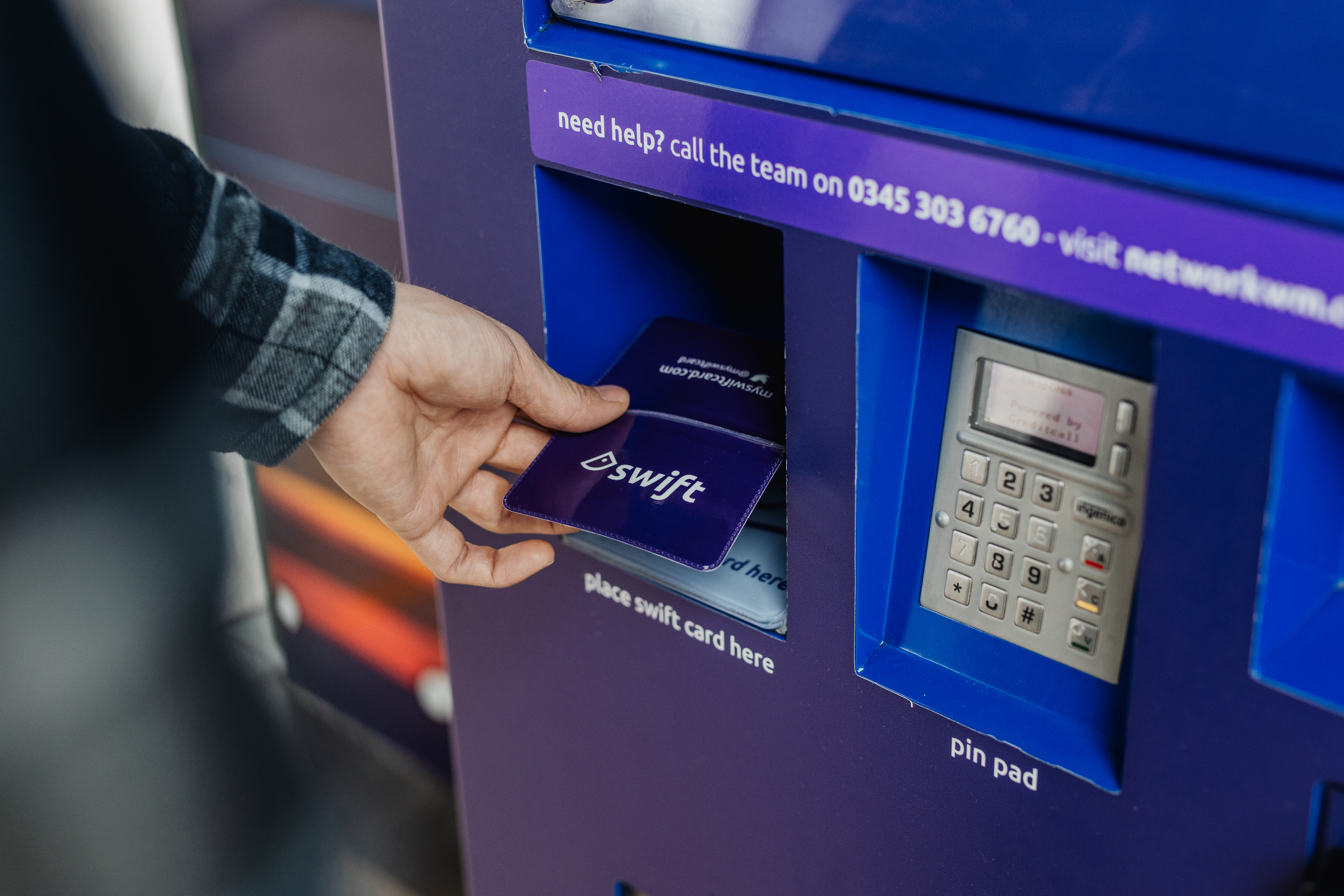 Person tapping transport card at machine